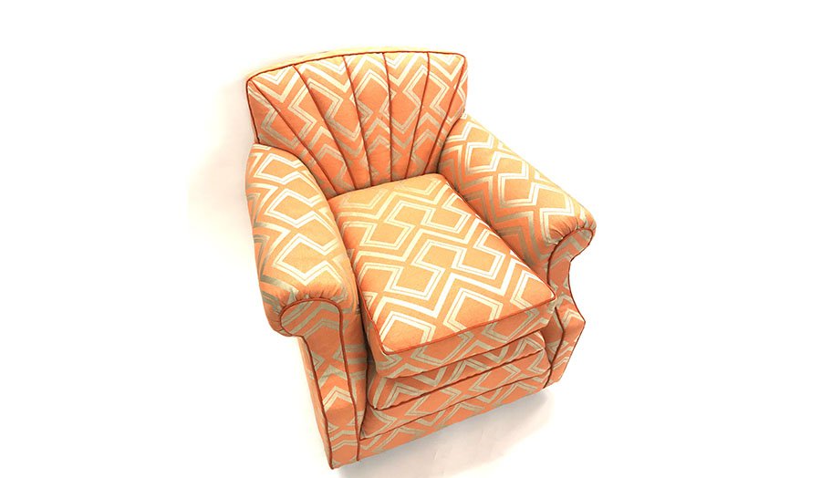 Traditional armchair with shallow fluted back and orange and cream fabric