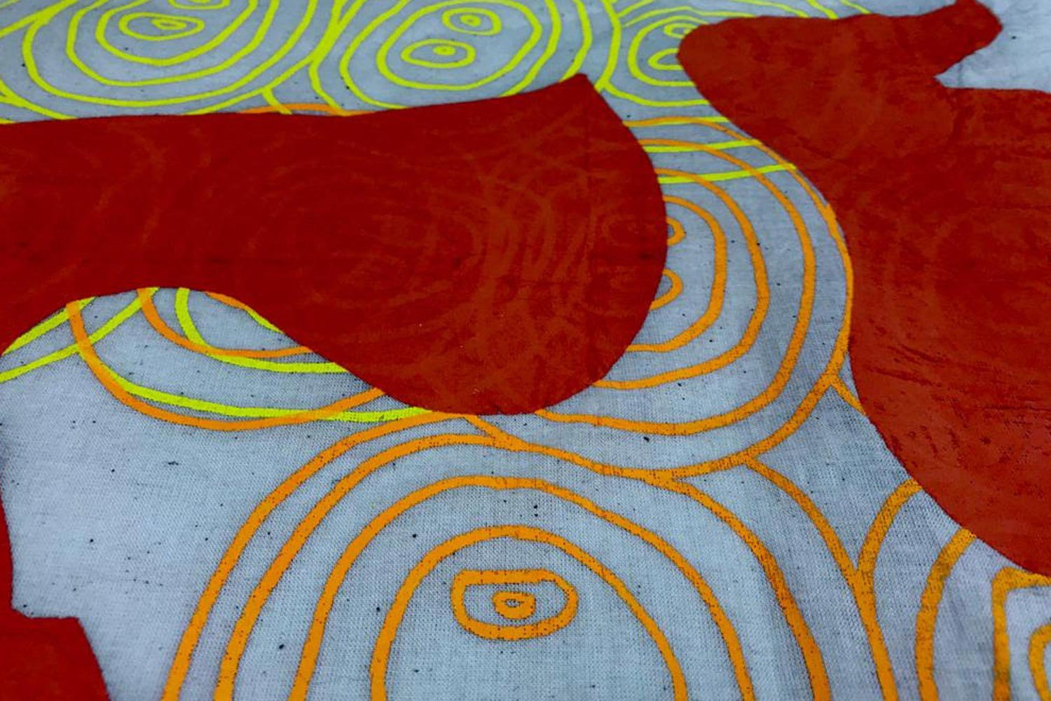 Detail of swirling printed pattern in reds, yellow and grey